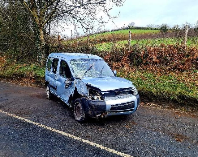 Firefighters deal with car on its side blocking the road
