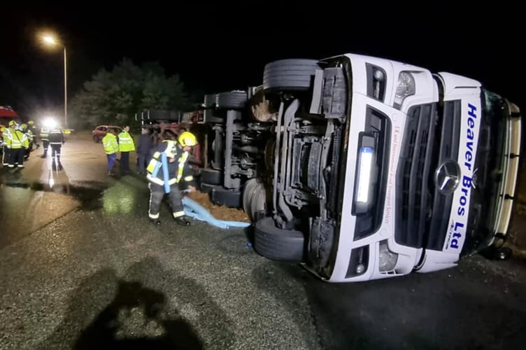 NEWTON Abbot's firefighters have released a picture of fire crews working overnight to protect the environment after an HGV tipped over. Picture: Newton Abbot Fire Station

