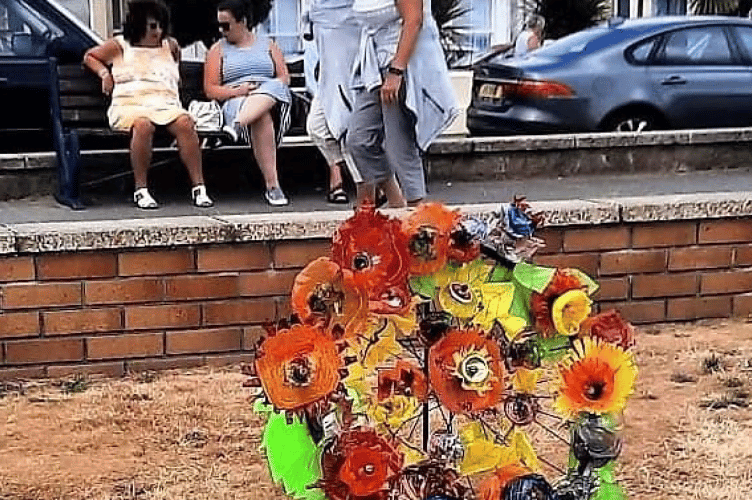 Memorial wreath of recycled flowers, mounted on a bicycle wheel