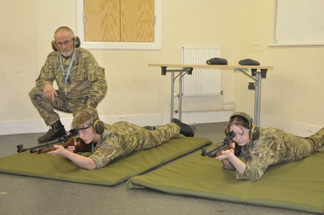 Under the watchful eye of Squadron Warrant Officer, Mike Vooght, Cadet Corporal Wakeham, left, and Cadet Rivers, right, take aim down range.