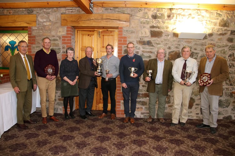 Donald Tonkin, fifth left, receiving the Devon County ploughing champion trophy from, fourth left, President Raymond Govier, pictured with other trophy winners with chairman Desmond Jenkin left, and third left, secretary, Sarah Hammett. AQ 2750