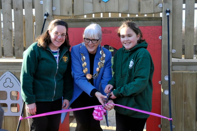 Cllr Sheila Brooke, centre, with local youngster Maddie, right, cutting the ribbon of 'Bovey Towers'