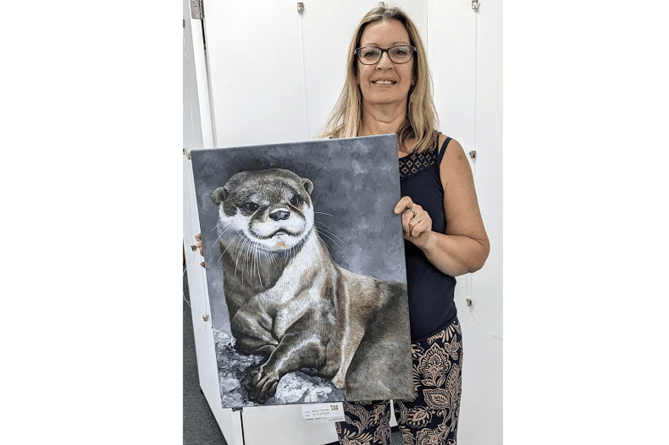Pictured is the talented local artist Sue Thomas, the award recipient at the last TAS Exhibition for her painting ‘Mr. P. Otter’.