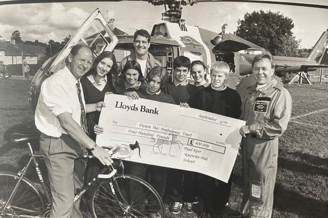 October 1995. Devon Air Ambulance plays a flying visit to Knowles Hill School in Newton - and in the process picks up a cheque for £400 from Peter Kerr, a teacher at the school.