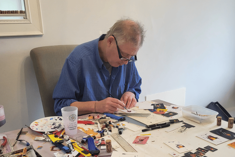 Artist John Skinner, now based in Newton Abbot, pictured at work creating his wine-based artwork for the gallery