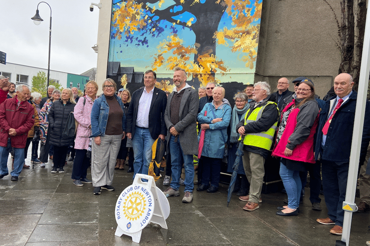 Artist Joe Webster is front and centre wearing a grey jacket and stood next to Newton Abbot MP Martin Wrigley.