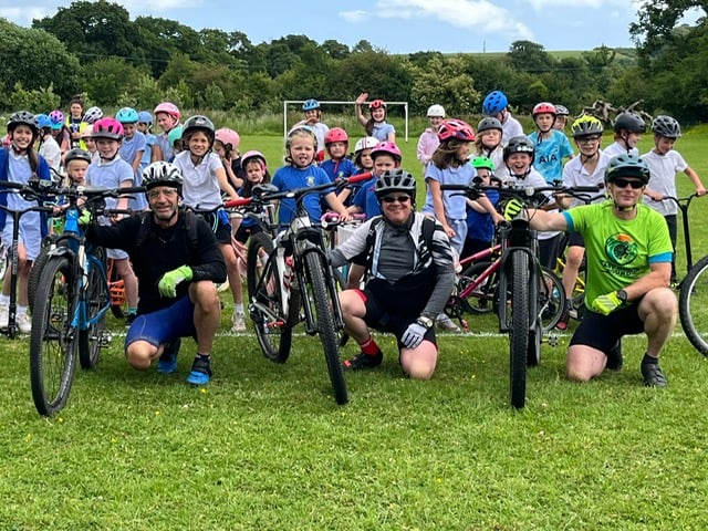 Children from Abbotskerswell Primary School welcome back fund-raising dads Tim Mitchell, Tim Wigram and Tony Degennaro after their fund-raising cycle ride 