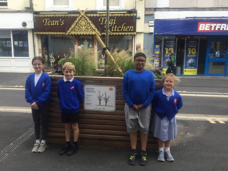 Iman, Frankie, Charlie and Ivy from All Saints March C of E primary school with the winning artwork in Queen Street, Newton Abbot.