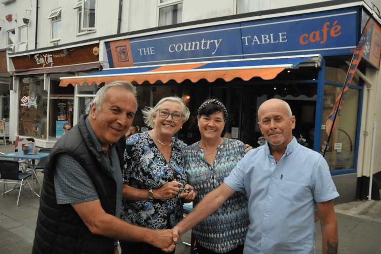 Karen and husband Alan, left, handing over the keys to Julie and husband Mark