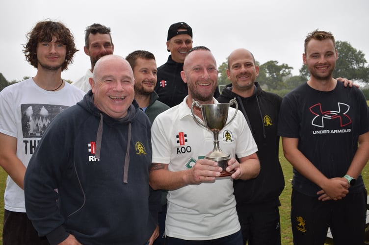 Abbotskerswell 2nd XI captain Aron Owen shows off the E Division West championship trophy. Pictured with him are members of the promotion winning team