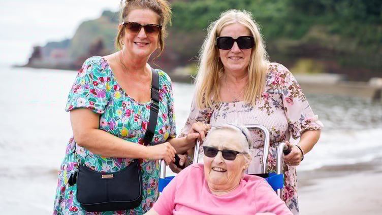 Julie Yates and Lisa Burge from the Sefton Hall care team at the beach in Dawlish with resident Shirley Mapston.