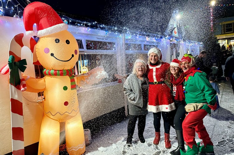Pictured left to right are Michelle Shorland of Dawlish Bowling Club, Ali Cross of Dawlish Chamber of Trade, Emma Nankervis Music Co-ordinator and Linda Marsh of Dawlish Community Transport standing outside of the Dawlish Gingerbread Cottage under a blizzard of snow. Photo supplied