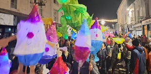 Children proudly carry Christmas lanterns in town parade 
