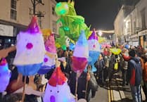 Children proudly carry Christmas lanterns in town parade