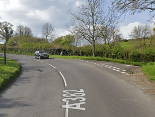 Fallen tree blocks moorland road 