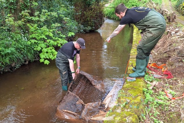Volunteers remove mattress dumped in waterway
