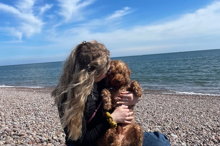 Maisie Bull on the beach with her dog Basil 