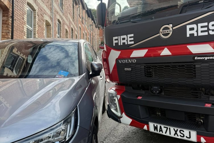 Newton Abbot firefighters manoeuvre their appliance past a parked car